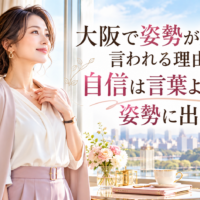 大阪城を望む明るく上品な部屋で、淡いピンクのジャケット姿の女性が胸元に手を添え、姿勢が重要な理由と自信が表情や立ち姿に表れる様子を示している。